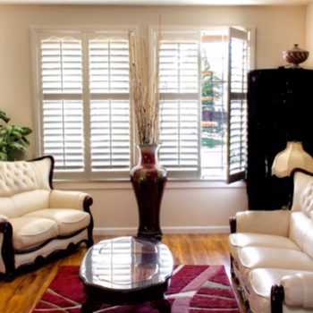 A living room with white furniture and wooden floors.